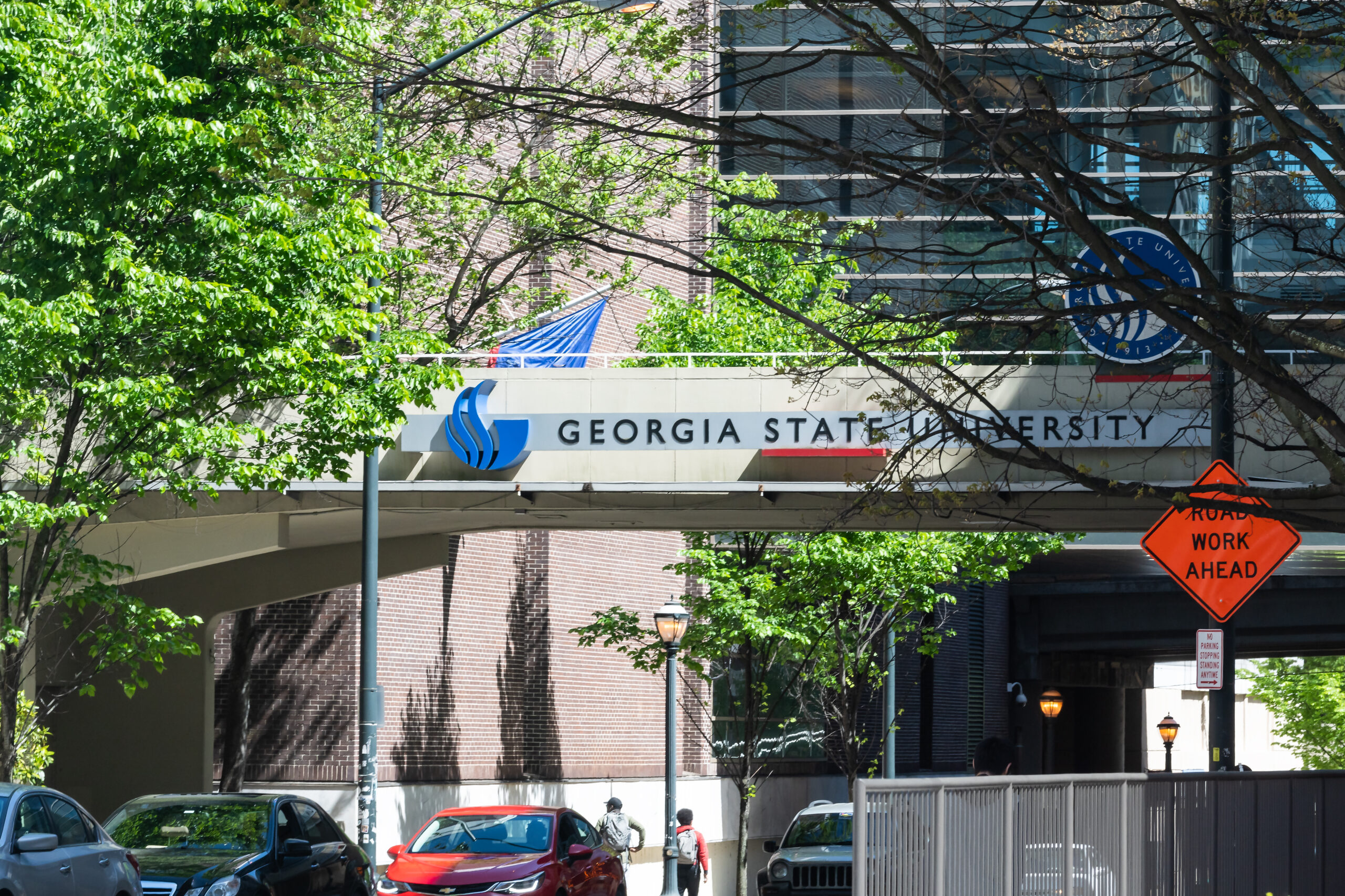 Georgia State University urban city campus with building hall sign and students walking in summer