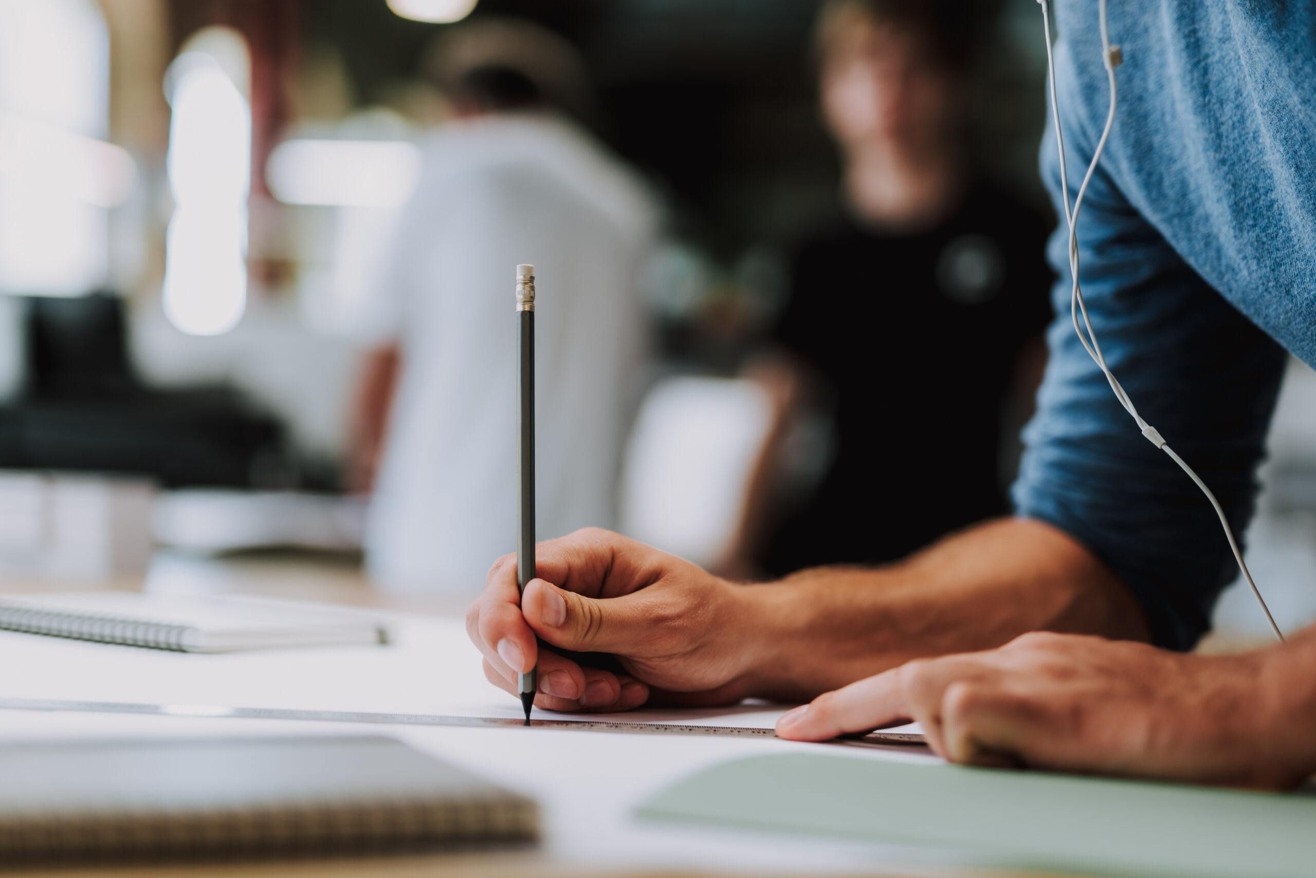 male using a pencil while working on a blueprint