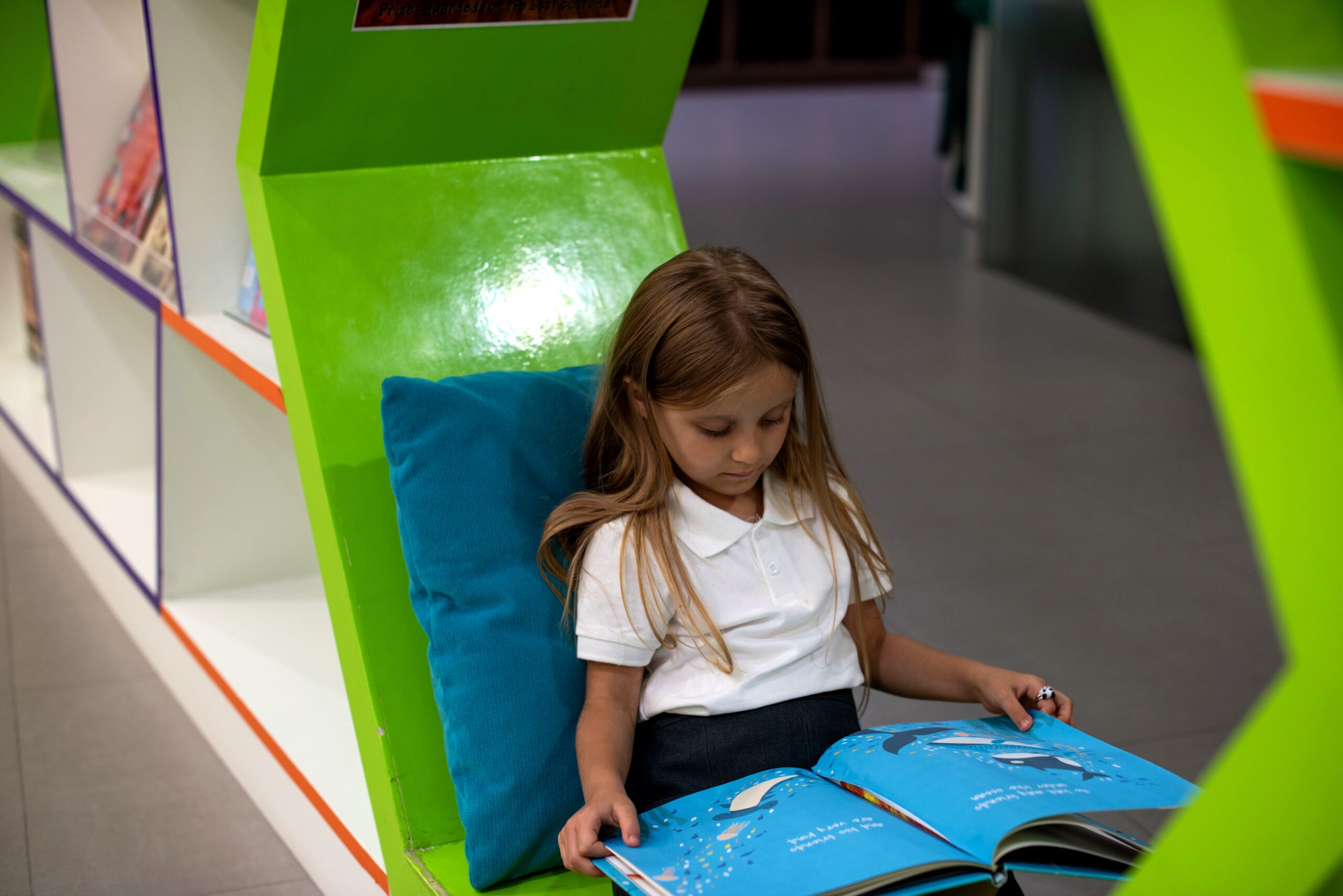 Child reading in library corner.