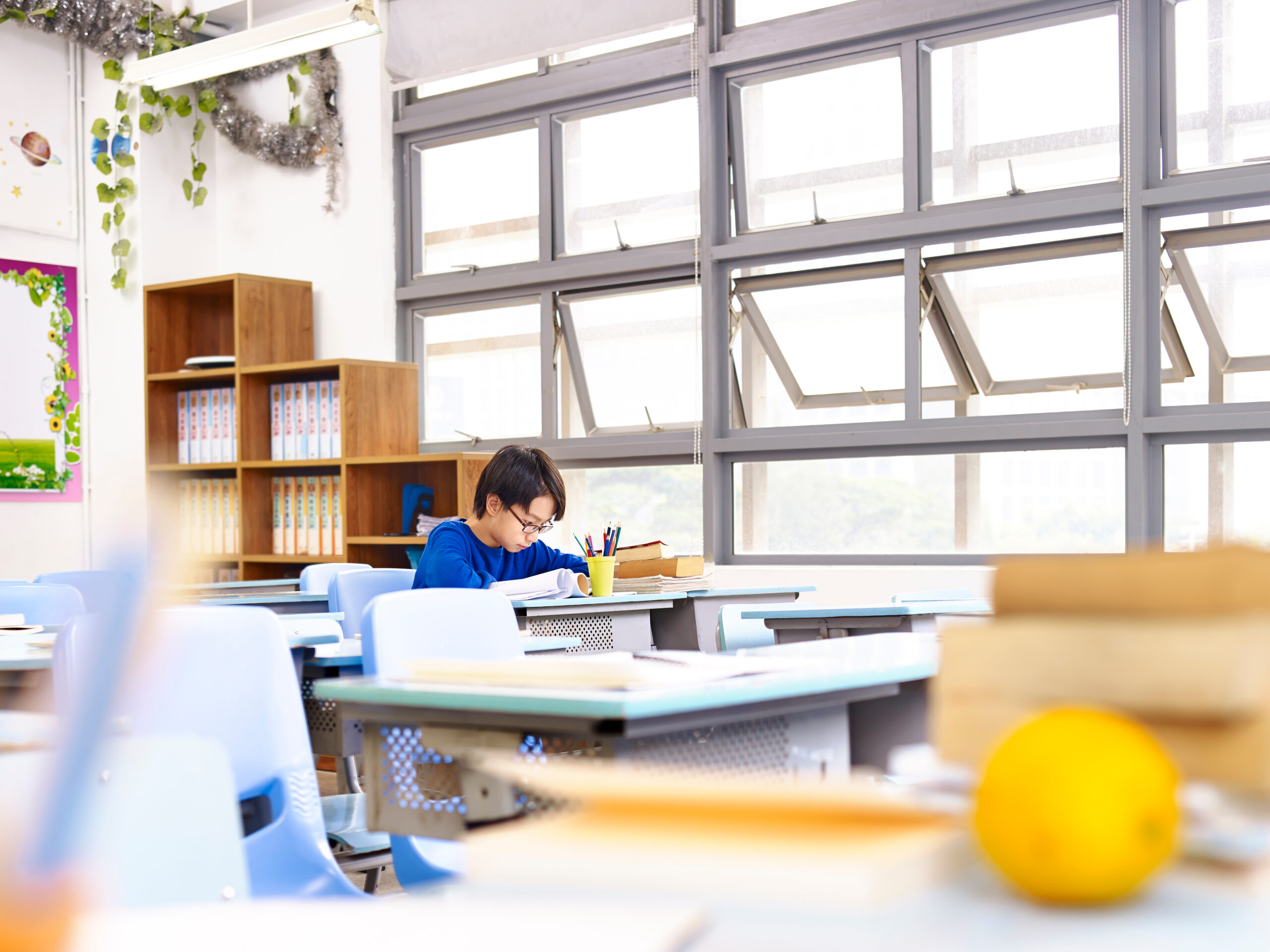 school boy studying alone in classroom.